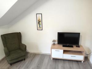 a living room with a television and a chair at Apartments Košević in Osijek