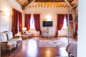 a living room with red curtains and a couch and a desk at Villa Nena in Tolentino