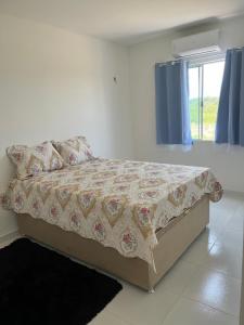 een slaapkamer met een bed met een bloemendeken bij Apartamento dois quartos com uma suíte in Ananindeua +12 foto's