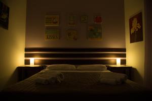 a bedroom with two towels on a bed with two lights at Le Terrazze Di Don Mariano in Cinisi