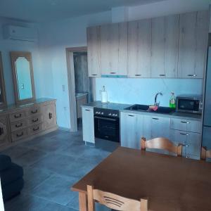 a kitchen with wooden cabinets and a sink and a table at Ιχνηλάτες in Agios Nikolaos