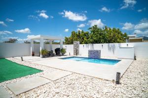 a backyard with a swimming pool and a white fence at La Vecchia Village Spacious Private Pool Area in Guayama