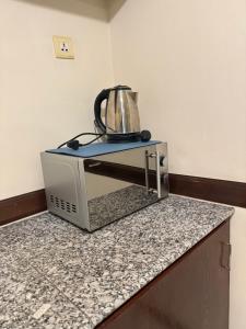 a tea kettle sitting on top of a toaster oven at A Famosa Condo Appartment Studio House 4 Pax Alor Gajah in Kampong Pulau Sebang
