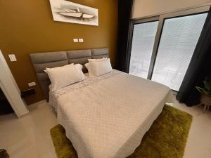 a bedroom with a bed with white sheets and pillows at Bubali Modern Suites Aruba in Palm-Eagle Beach
