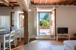 サン・ジョヴァンニ・ダッソにあるAlloggio Val D'orcia con Balcone Panoramico 6' Posti Lettoのテーブルとテレビのあるリビングルーム