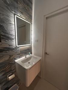 a bathroom with a sink and a mirror on the wall at Bubali Modern Suites Aruba in Palm-Eagle Beach +23 photos