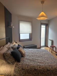 a bedroom with a bed with pillows and a window at Burnay Porto Suites in Porto