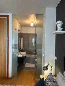 a bathroom with a glass shower with a sink at Burnay Porto Suites in Porto