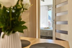 a vase of flowers on a table in a room at Apartment Pegaz & Aqua Marina in Świnoujście