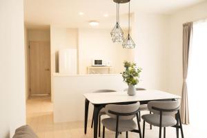 Una cocina y un comedor con mesa y sillas. en Hotel Tomas Shirahama, en Uruma