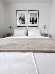 a large white bed with three pictures on the wall at Wonderful apartment in Sablon in Brussels