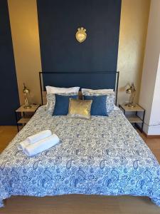 a bedroom with a bed with a blue comforter at Burnay Porto Suites in Porto +23 photos