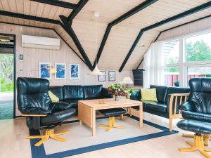 a living room with black leather furniture and a table at 4 star holiday home in Rømø in Kongsmark