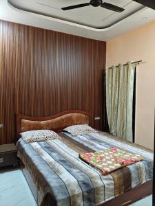 Un dormitorio con una cama grande con ventilador de techo. en Maa Shanti Guest House, en Sehore