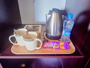 Una bandeja con dos tazas de café y una bebida. en Madalitso Guest House & Airport Services, en Lusaka
