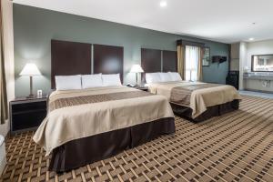 Ένα ή περισσότερα κρεβάτια σε δωμάτιο στο Scottish Inns & Suites