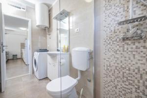 a white bathroom with a toilet and a shower at Nane Garden house with heated pool in Mirce +14 photos