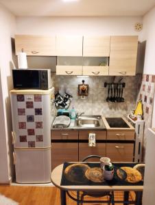 a kitchen with a white refrigerator and a table at Studio - Bee Happy in Sarajevo