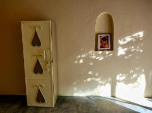a refrigerator in a room with a picture on the wall at Under The Tree in Al Ḩamrāʼ