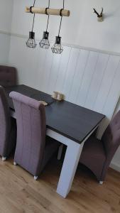 einen Esstisch mit 2 Stühlen, einem Tisch und 2 Leuchten in der Unterkunft Ferienwohnung in Windischeschenbach