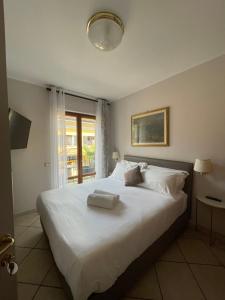 a bedroom with a large white bed with towels on it at Residence Villa Margherita WITH POOL & HYDROMASSAGE in Cannobio +74 photos
