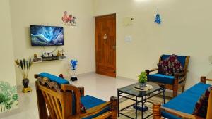 Una sala de estar con un sofá y sillas y una mesa. en Marvic Homes, en Siolim