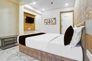 Un dormitorio con una cama grande y un televisor. en Hotel O N R, en Ahmedabad