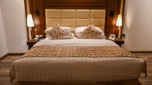 a large bed in a hotel room with two lamps at Helat Hotel in Al Khobar +49 photos