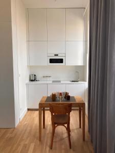 a kitchen with a wooden table and a kitchen with white cabinets at Studio in Narbonne