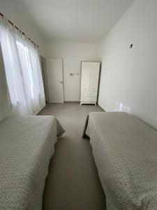 two beds in a room with white walls and windows at Sol y olas in Playa Unión