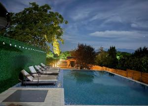 a swimming pool with lounge chairs next to a fence at Meidan Oda Holiday Homes in K'obulet'i