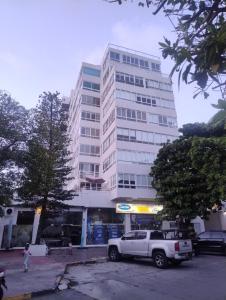 a white truck parked in front of a tall building at Bahía Fragata 204 in San Andrés