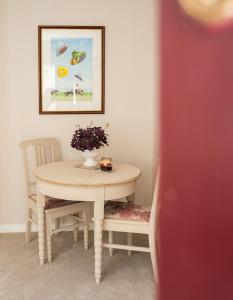 une table et des chaises avec un vase de fleurs dans l'établissement Milliners Court - One-Bed Cottage in Central Bath, à Bath 10 autres photos