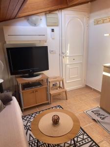 a living room with a tv and a table at MG Guest Room in Alcossebre