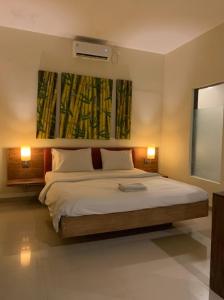 ein Schlafzimmer mit einem Bett und einem Gemälde an der Wand in der Unterkunft Marinos Place Legian in Legian