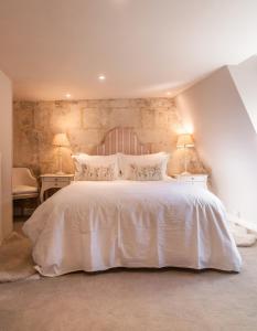 une chambre avec un grand lit blanc avec deux lampes dans l'établissement Milliners Court - One-Bed Cottage in Central Bath, à Bath