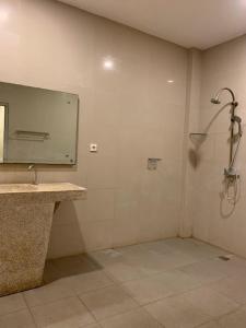 ein Badezimmer mit Dusche, Waschbecken und Spiegel in der Unterkunft Marinos Place Legian in Legian