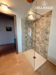 a glass shower in a room with a wall at Dellavalle Guest House in Vigliano d'Asti