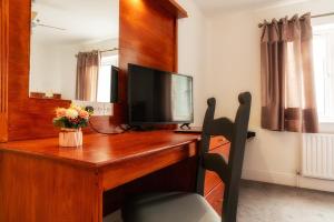 a wooden desk with a television on top of it at Club Wokingham Hotel in Wokingham