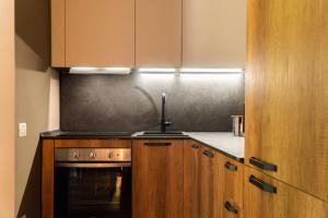 a kitchen with wooden cabinets and a stove at Maison Poluc - Suite Alpine in Champoluc