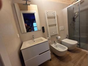 a white bathroom with a sink and a toilet at Santa Caterina Home 16 in Altamura +18 photos