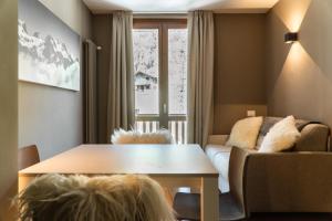 a living room with a table and a couch at Maison Poluc - Suite Alpine in Champoluc +5 photos