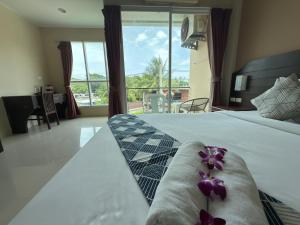 a hotel room with a bed with purple flowers on it at JR Siam Inn Resort in Kata Beach +66 photos