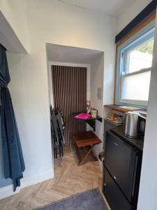 una cucina con tavolo, sedie e porta di The Guest Room at Champs Cottage a Isle of Jersey Altre 23 foto