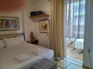 a bedroom with a white bed and a window at Rethymno Blue in Rethymno Town