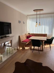 una sala de estar con una mesa y un sofá en Wohnen über den Dächern am Meranplatz, en Bad Aussee