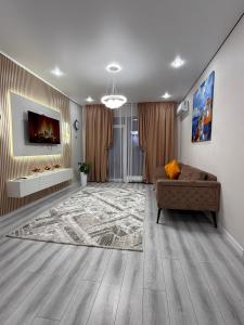 ein Wohnzimmer mit Sofa und Fernseher in der Unterkunft 4YOU Shymkent евро2 in Schymkent + 6 Fotos