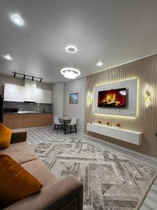 ein Wohnzimmer mit Couch und Kamin in der Unterkunft 4YOU Shymkent евро2 in Schymkent