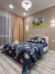 ein Schlafzimmer mit einem Bett mit einer blauen Bettdecke in der Unterkunft 4YOU Shymkent евро2 in Schymkent
