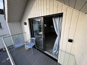 a screened in porch with two chairs and a window at Chalet Orkanger - Close to Everything, Far from Ordinary in Orkanger